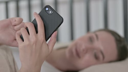 Woman Relaxing in Bed Using Smartphone