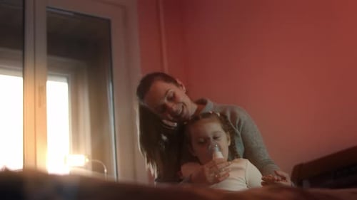 Mother Comforts Child Using Nebulizer in Bedroom