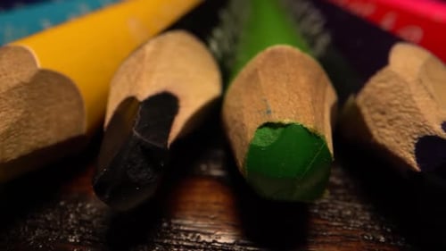 Viele Buntstifte liegen in einer Reihe. Schieben Sie über Bleistifte auf dem Tisch. Makroaufnahme auf Laowa-Objektiv.