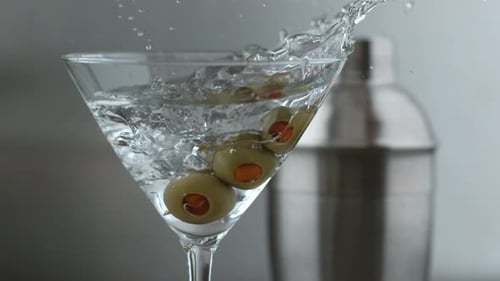 Olives Dropping Into Martini Glass with Splash