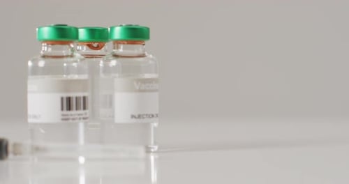 Video of close up of vaccine vials on white background