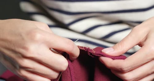 Adult Sewing Burgundy Cloth by Hand Close Up