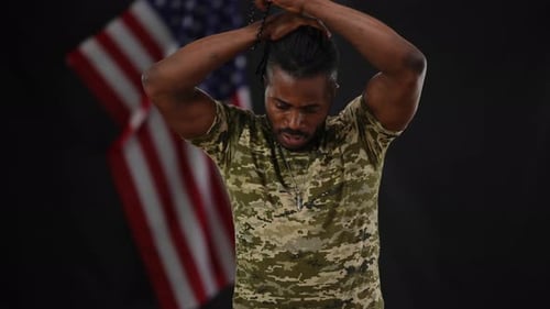 Portrait of Handsome Confident African American Soldier Tying Ponytail with Dreadlocks and Looking