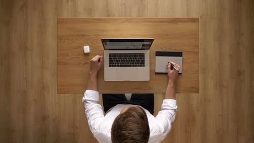 Freelancer arbeitet an Laptop und Grafik-Tablet