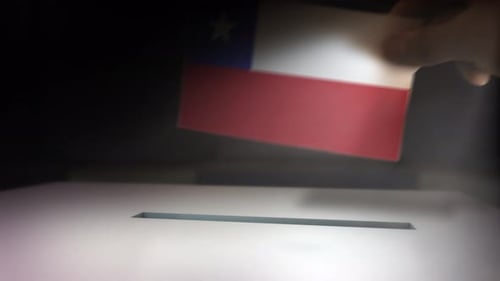 Hand Inserts National Flag Ballot into Election Box