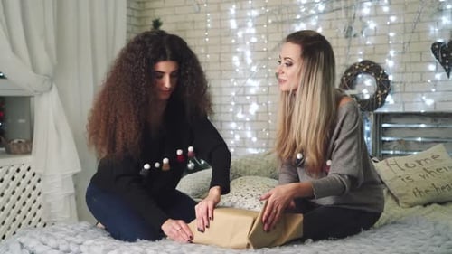 Two Women Wrapping Christmas Gift Together