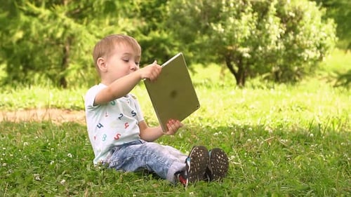 Happy Boy Playing in Tablet Outdoors