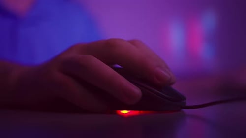 Nahaufnahme der Hand eines Mannes, der zu Hause arbeitet, auf die Tasten einer Computermaus klickt und eine Schriftrolle dreht