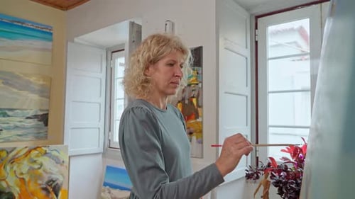 Woman Paints Artwork in Bright Studio