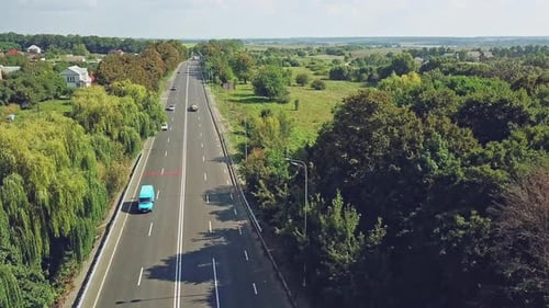 Aerial view of beautiful landscape of rural place with a wide road and cars on it in a sunny day
