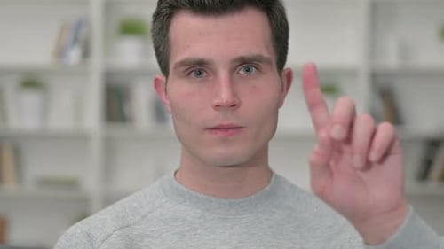 Young Man Indicates No with Finger Gesture