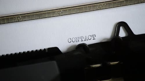 Vintage Typewriter Types the Word Contact on Paper