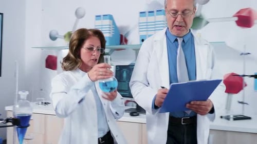 Team of Mature Scientists Talking While Walking in Modern Laboratory
