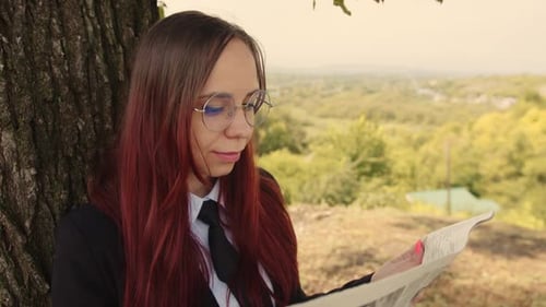 Concentrated Elegant Lady Reading Newspaper in Park