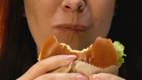 Woman Eating Hamburger With Disgust, Refusing Unhealthy Junk Food, Close Up