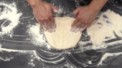 The Cook's Hands Take a Lump of Dough, Put It on the Table and Knead It Into a Pizza Circle. Top