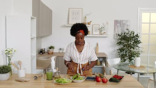 Woman Prepares Fresh Salad in Modern Kitchen
