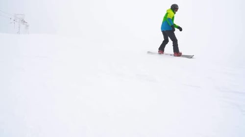 Extreme Snowboarder Riding Fresh Powder Snow Down the Steep Mountain Slope