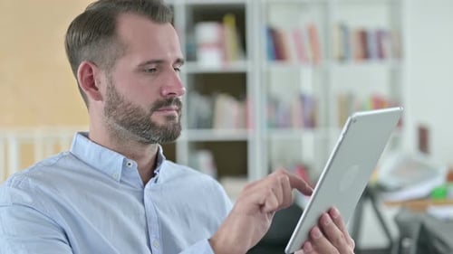 Adult Male Using Tablet Indoors