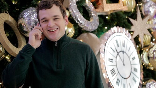Smiling Man Talking on Phone by Christmas Tree