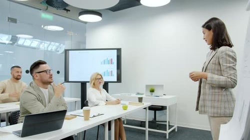 Young Woman Making Presentation To Colleagues Discussing Business in Office