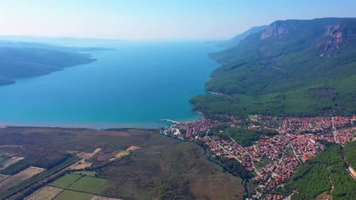 Blick von oben auf das Tal mit Stadtgebäuden und Meer zwischen Bergen