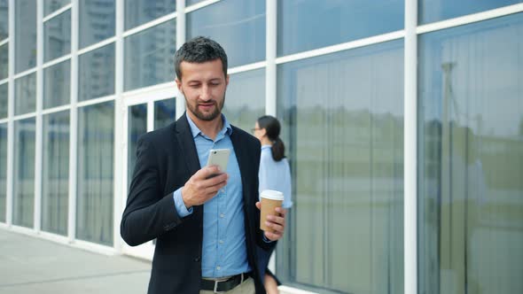 Medium Shot of Businessman Walking in Business District Checking ...