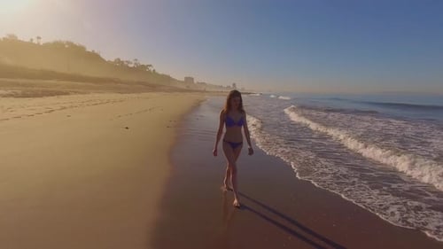 Woman Walking On The Beach
