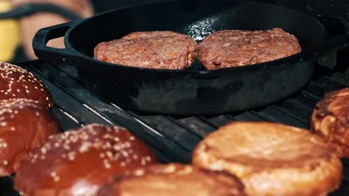 Frying patties and burger buns in a frying pan and grill. BBQ