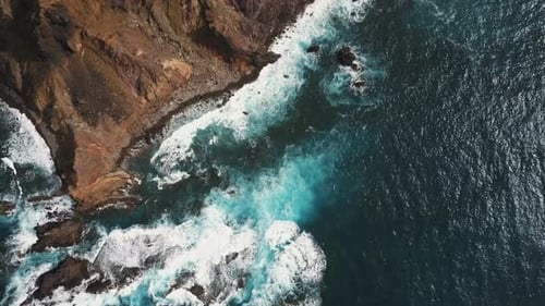 Aerial Top View of Ocean Waves Breaking on Rocks. Blue Water and White Foam on Tenerife, Canary