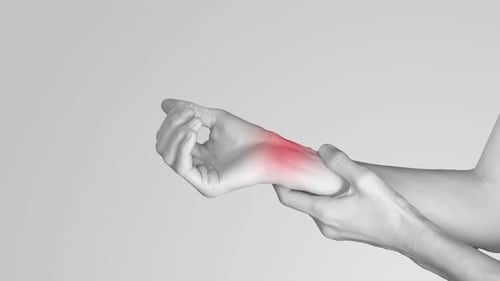 Hand holding wrist with joint pain