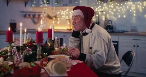 Senior Man in Santa Hat Alone at Christmas