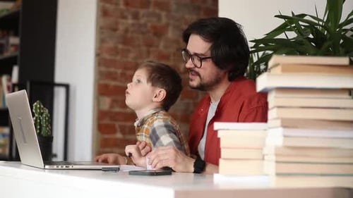 father with a son at working place in home office