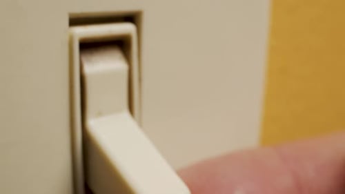 Foto macro de um dedo ligando um interruptor de luz