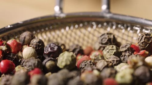 Vibrant Mixed Peppercorns in a Metal Strainer