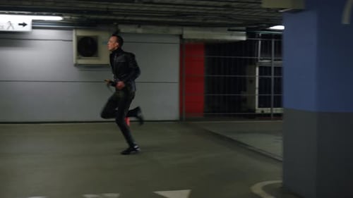 Man Running from Police Car in Parking Garage