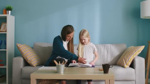 Woman Reading With a Child on a Couch