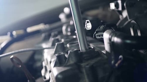 Mechanic Removing Spark Plug from Car Engine