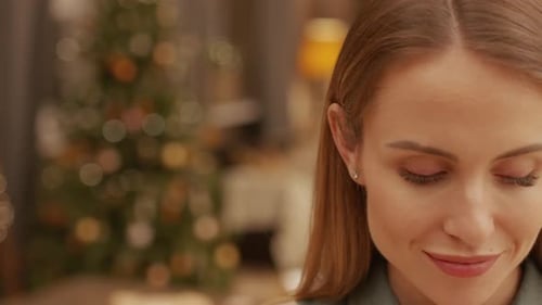 Smiling Woman in Front of Christmas Tree