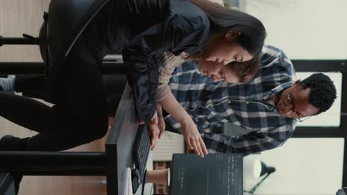 Three Young Adults Collaborating on Computer in Office