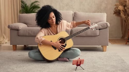 Woman Plays Guitar at Home for Online Lesson