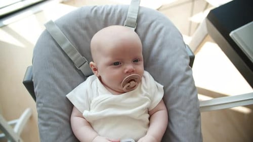 Beautiful Shot of Baby Girl in Rocker with a Pacifier