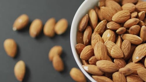 Video of fresh fruit almonds in a bowl on grey background
