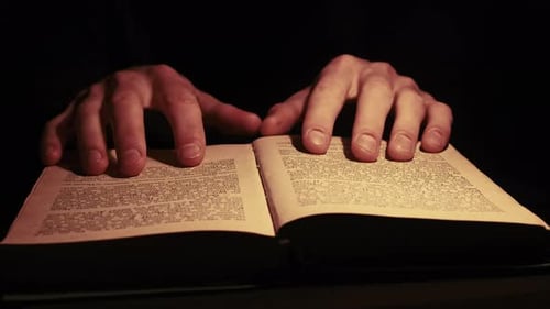 Hands Reading Pages of an Antique Book