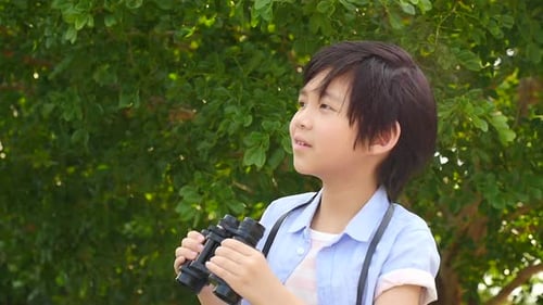 Cute Asian Child Using Binocular On Summer Day