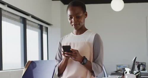 Woman Smiling in Bright Office Using Cell Phone