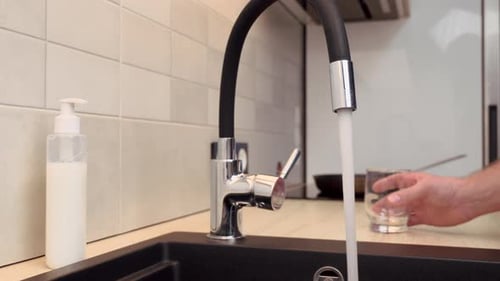 Filling Glass with Water at Kitchen Sink