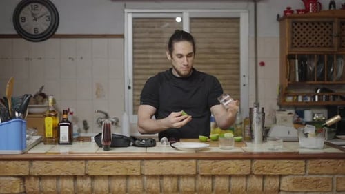 Young Adult Squeezes Limes for Cocktail Preparation