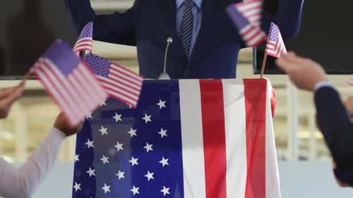 Politician Gives Speech with American Flags and Podium