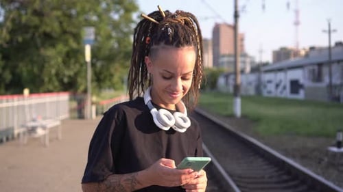 Young Attractive Woman with Smartphone at the Railway Station